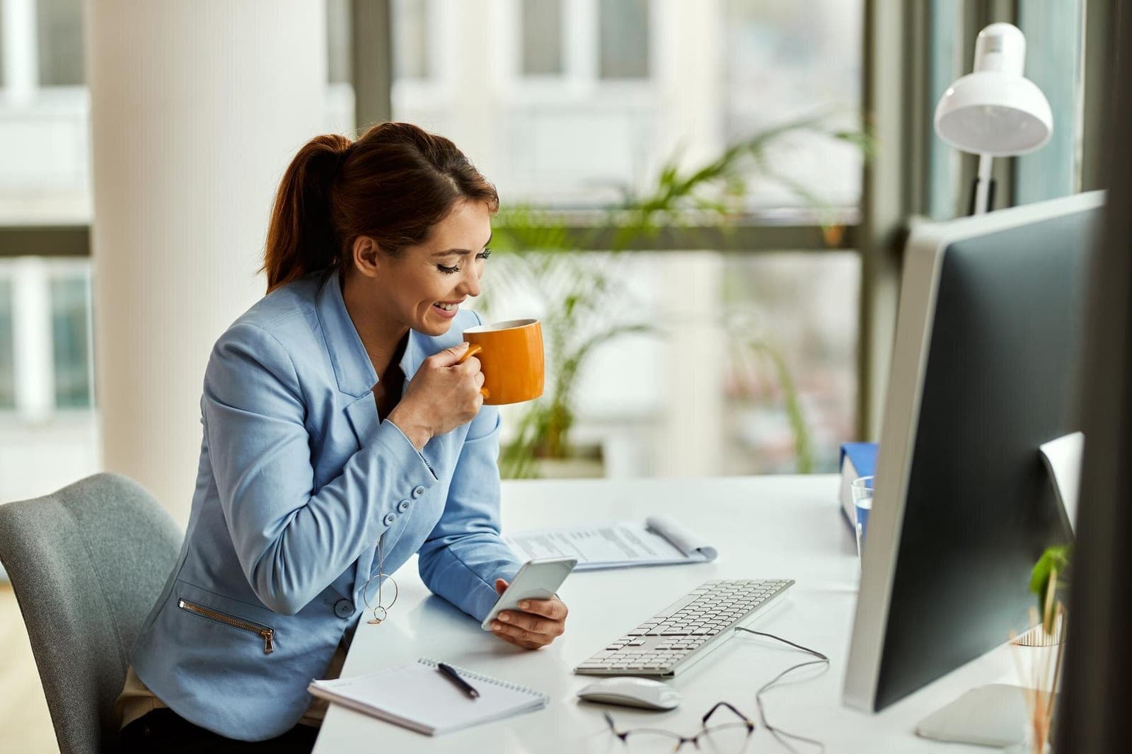 A property manager checking her phone over morning coffee
