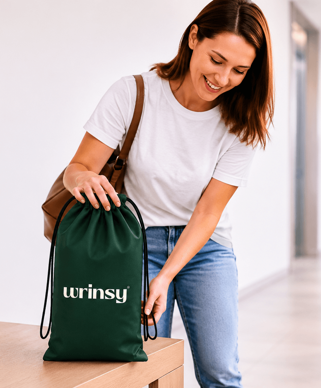 A resident placing folded laundry into a wrinsy bag